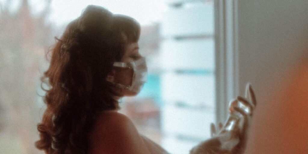 woman in a mask holding a bag of saline