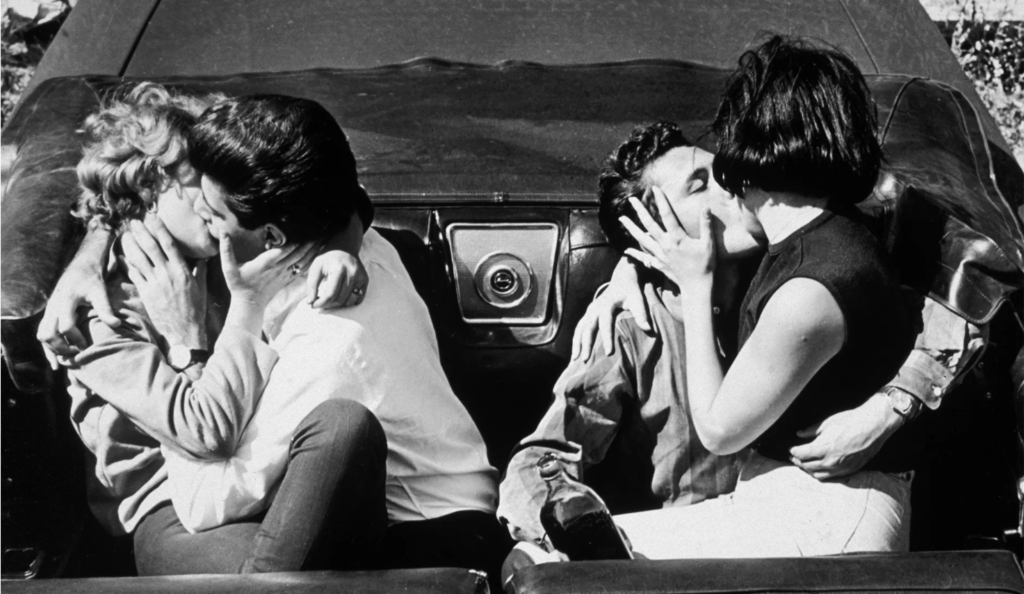 two couples kissing in a convertible c. 1950s